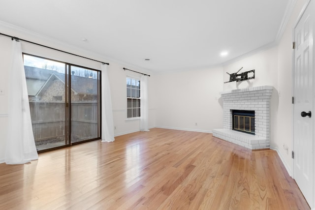 unfurnished living room featuring a fireplace, ornamental molding, and light wood-type flooring