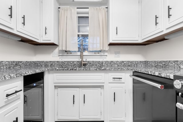 kitchen featuring white cabinetry and light stone counters