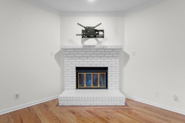 details featuring ornamental molding, hardwood / wood-style floors, and a fireplace