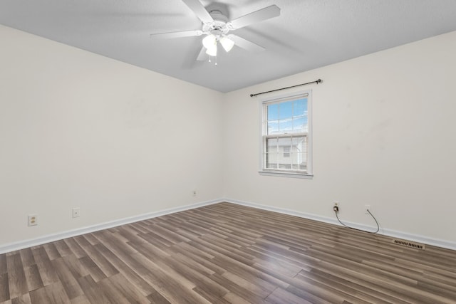 unfurnished room with ceiling fan, dark hardwood / wood-style flooring, and a textured ceiling