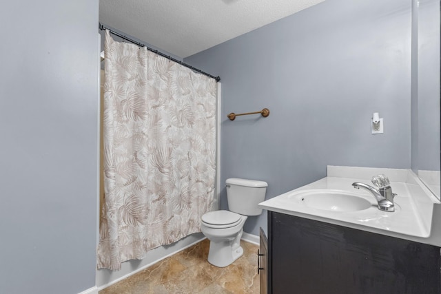 bathroom with vanity, toilet, and a textured ceiling