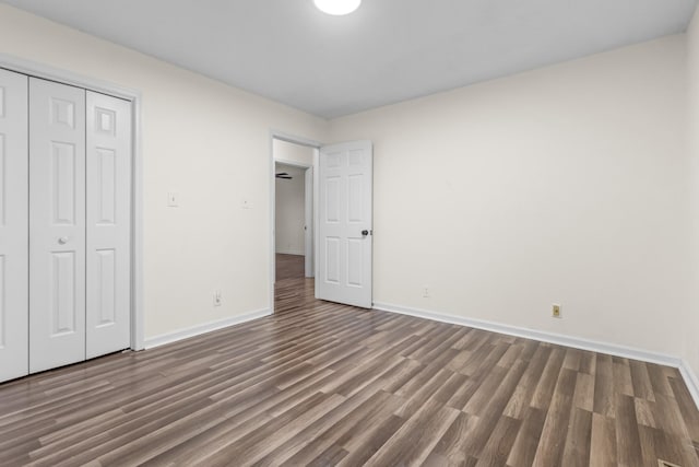 unfurnished bedroom with dark hardwood / wood-style floors and a closet