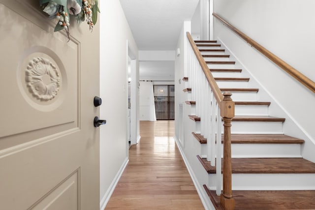 stairway featuring hardwood / wood-style flooring and a textured ceiling