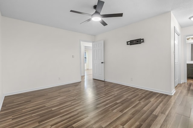 empty room featuring dark wood-type flooring and ceiling fan