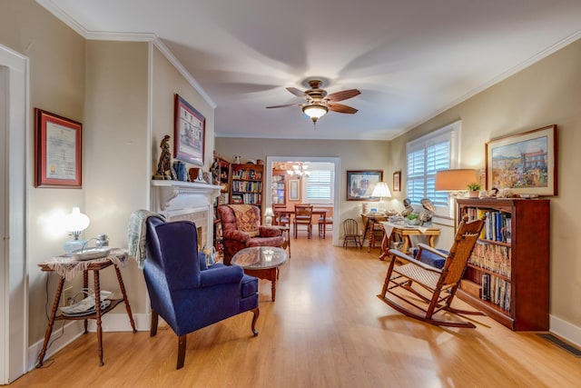 sitting room with ornamental molding, ceiling fan with notable chandelier, and light hardwood / wood-style flooring