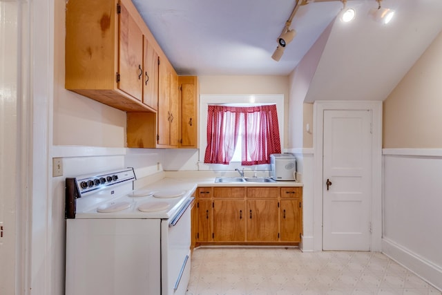 kitchen with white electric stove, rail lighting, and sink