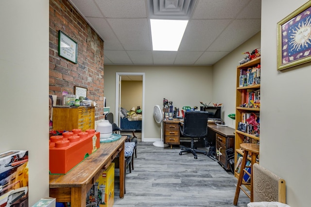 office area with a drop ceiling and light wood-type flooring