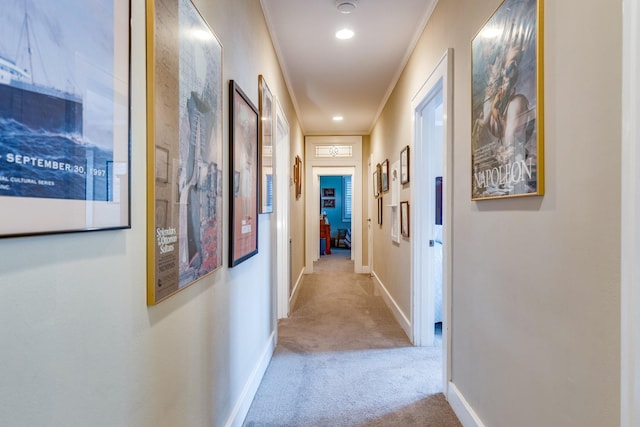 corridor featuring ornamental molding and light carpet