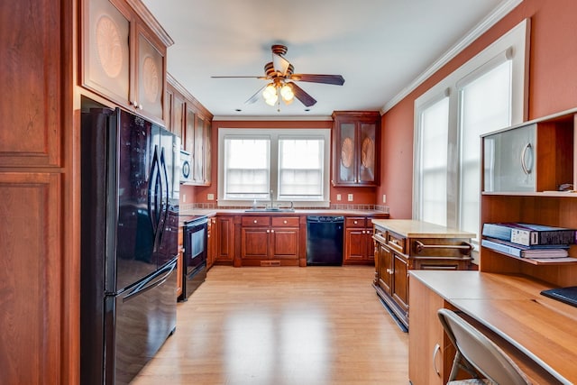 kitchen featuring sink, ornamental molding, ceiling fan, light hardwood / wood-style floors, and black appliances