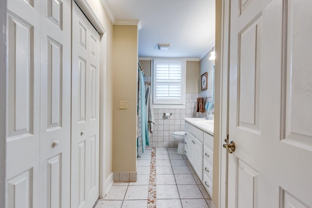 bathroom featuring ornamental molding, vanity, toilet, and tile walls