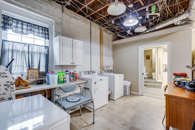 clothes washing area with washing machine and dryer and cabinets