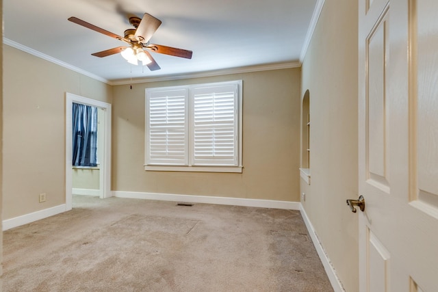 unfurnished room with crown molding, light colored carpet, and ceiling fan