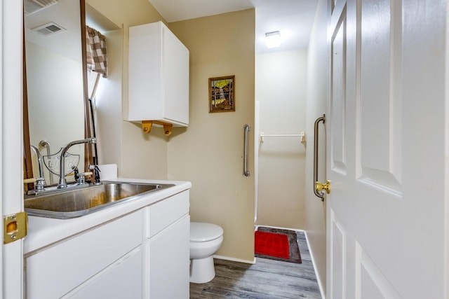 bathroom with vanity, hardwood / wood-style floors, and toilet