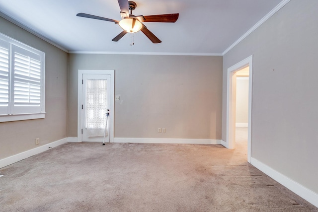 empty room featuring light colored carpet, ornamental molding, and ceiling fan