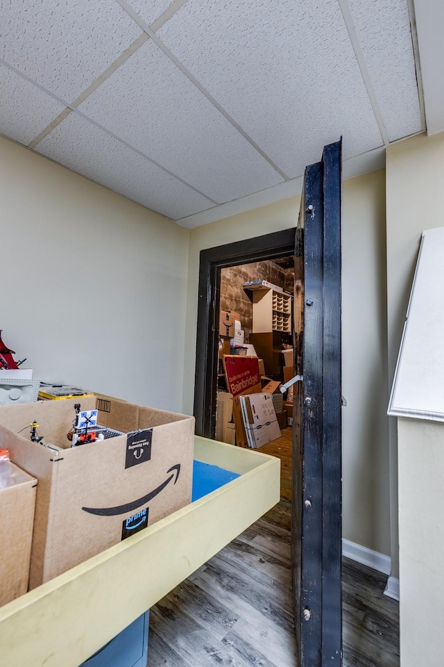 interior space featuring a drop ceiling and dark wood-type flooring