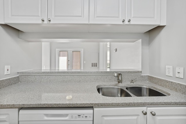 kitchen with white cabinetry, white dishwasher, sink, and light stone counters