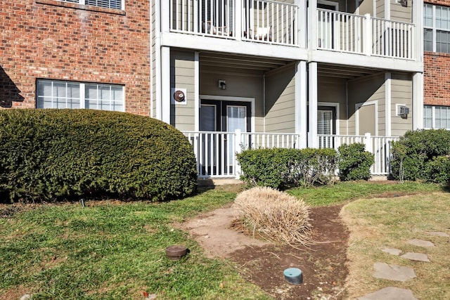 view of exterior entry with a yard