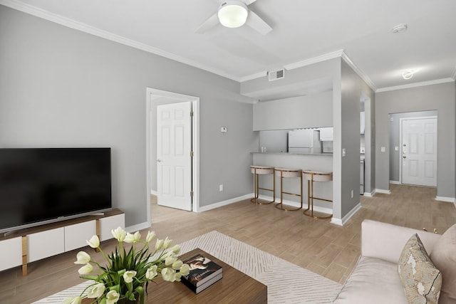 living room with ornamental molding, ceiling fan, and light hardwood / wood-style flooring