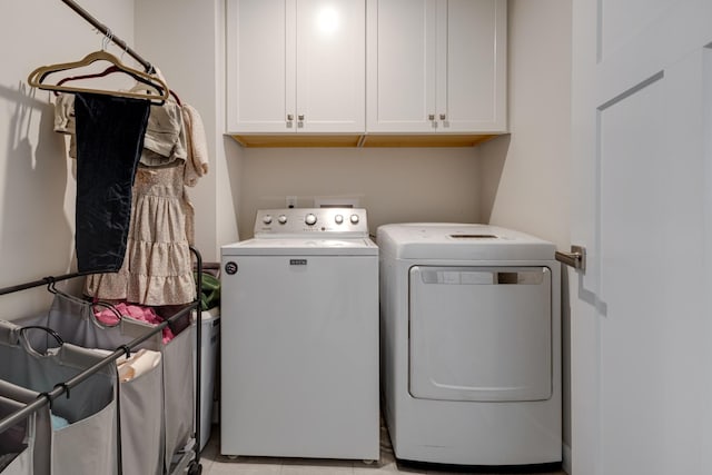 washroom with cabinets and washing machine and clothes dryer