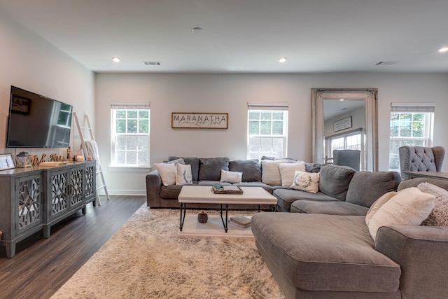 living room with dark wood-type flooring and a wealth of natural light