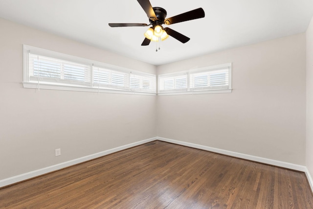 spare room featuring ceiling fan, a healthy amount of sunlight, and dark hardwood / wood-style flooring