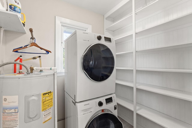 washroom with stacked washer / drying machine and electric water heater