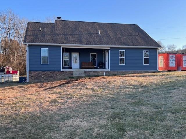 rear view of house featuring a yard