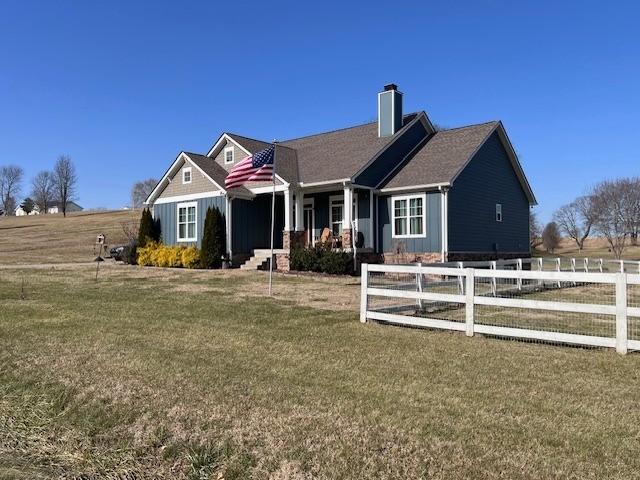 view of front of property with covered porch and a front lawn