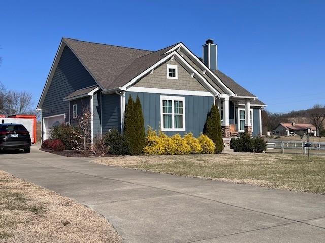 view of side of home featuring a garage and a lawn