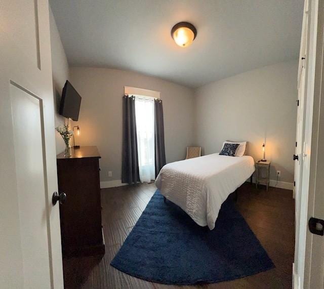 bedroom with dark hardwood / wood-style floors