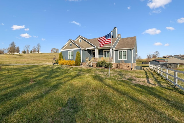 view of front of property with board and batten siding, fence, a front yard, cooling unit, and a chimney