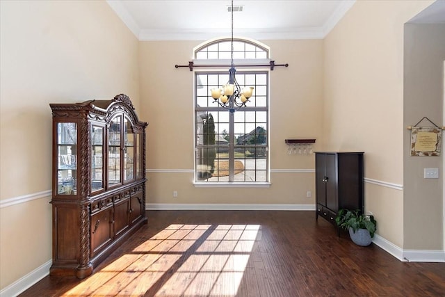 interior space featuring dark wood-type flooring, ornamental molding, and a chandelier