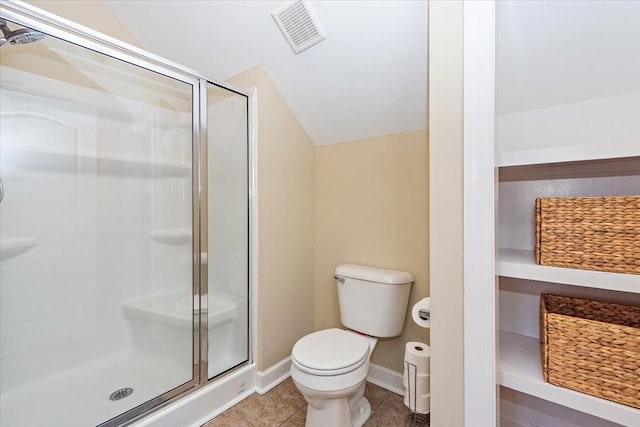 bathroom featuring a shower with door, lofted ceiling, tile patterned floors, and toilet