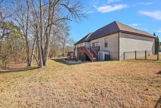 view of side of home featuring a wooden deck and a yard