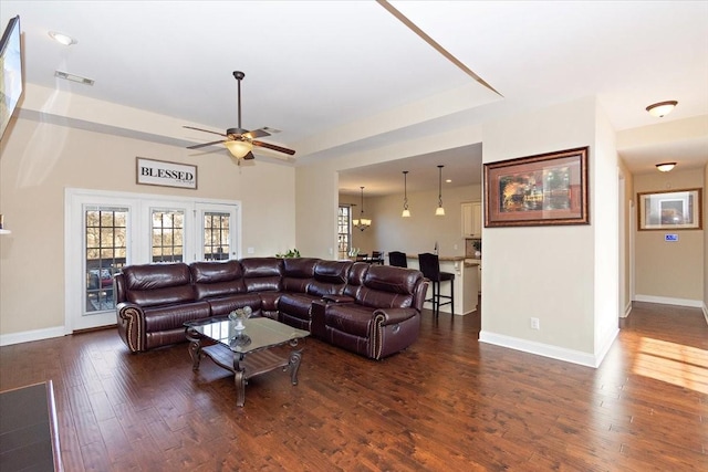 living room with dark hardwood / wood-style floors and ceiling fan