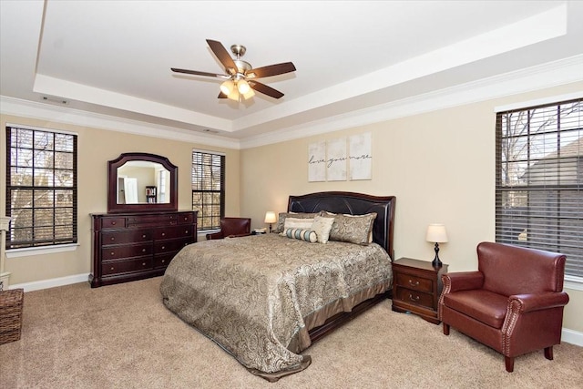 carpeted bedroom with crown molding, ceiling fan, and a raised ceiling