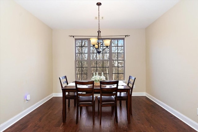 dining space featuring dark wood-type flooring and a chandelier