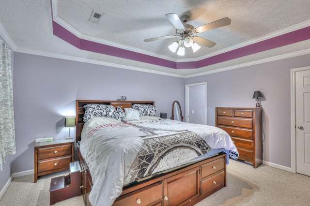 carpeted bedroom featuring ceiling fan, a tray ceiling, ornamental molding, and a textured ceiling