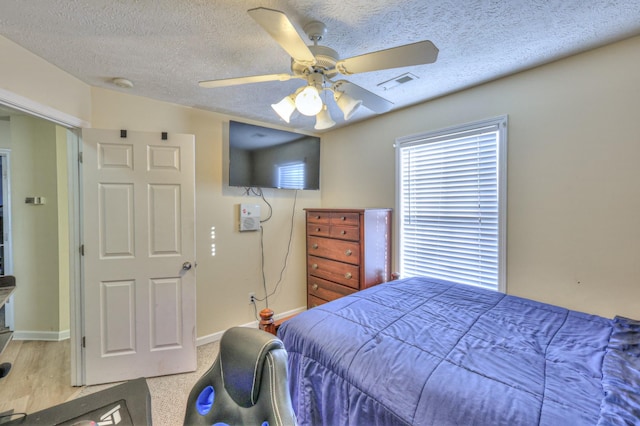 bedroom featuring ceiling fan and a textured ceiling