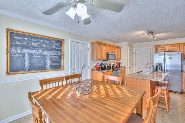 dining area featuring sink, ornamental molding, and a textured ceiling