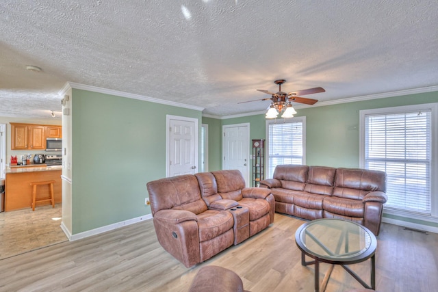 living room with crown molding, a textured ceiling, ceiling fan, and light wood-type flooring