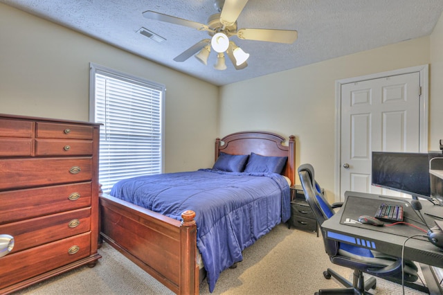 carpeted bedroom with multiple windows, ceiling fan, and a textured ceiling