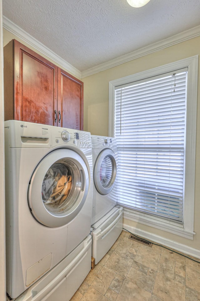 laundry room featuring separate washer and dryer, crown molding, cabinets, and a textured ceiling