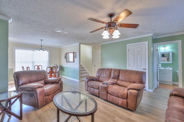 living room featuring ornamental molding, light hardwood / wood-style floors, and a textured ceiling