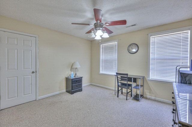 carpeted office with ceiling fan and a textured ceiling