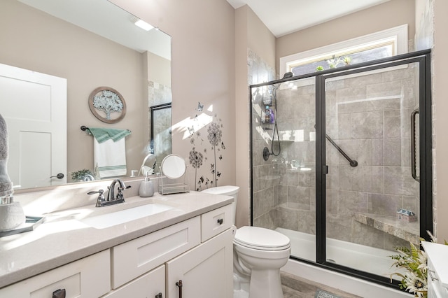 bathroom with vanity, an enclosed shower, and toilet