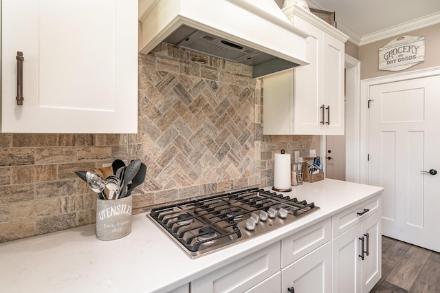 kitchen featuring white cabinetry, tasteful backsplash, ornamental molding, stainless steel gas cooktop, and custom exhaust hood