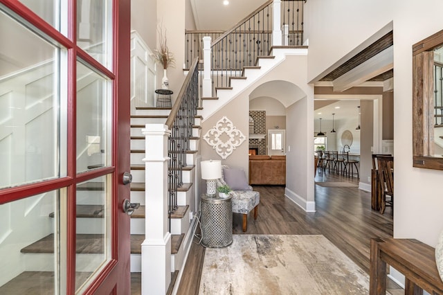 foyer entrance with dark wood-type flooring and a high ceiling