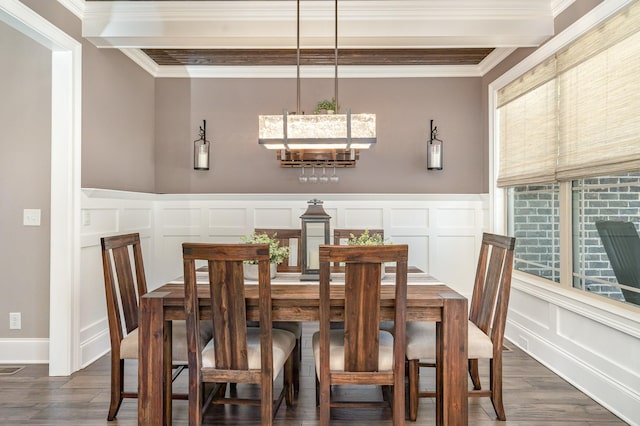 dining area featuring dark hardwood / wood-style flooring, a notable chandelier, and crown molding