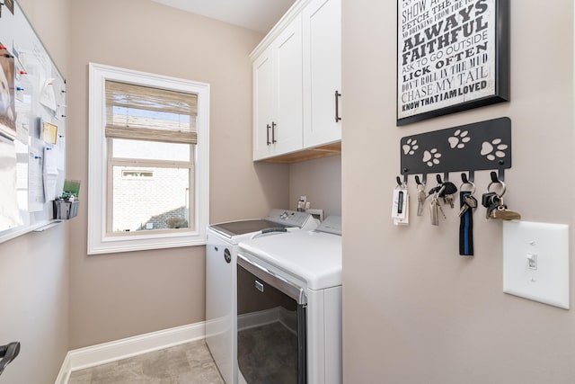 clothes washing area featuring cabinets and washer and dryer